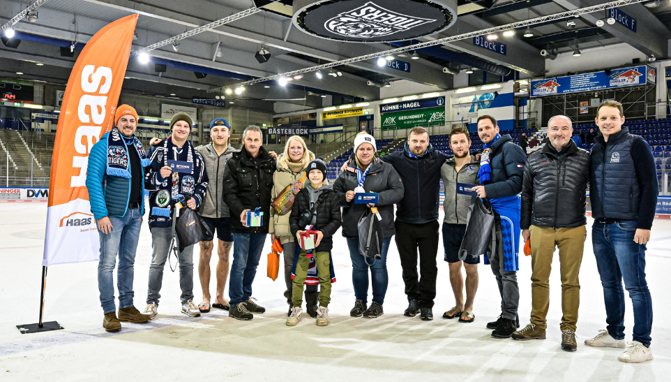 Bild zeigt die Gewinner der 50/50 Lotterie und der Zusatzpakete, die Geschäftsführung der Straubing Tigers, der Haas Unternehmensgruppe und zwei Eishockeyspielern der aktuellen Saison  