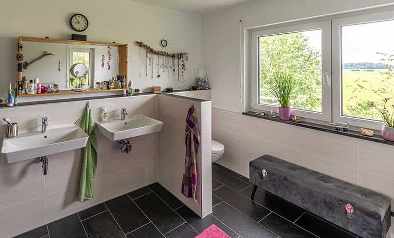 Badezimmer mit zwei Waschbecken, Spiegel und Sitzbank im Doppelhaus Haas D 112 D