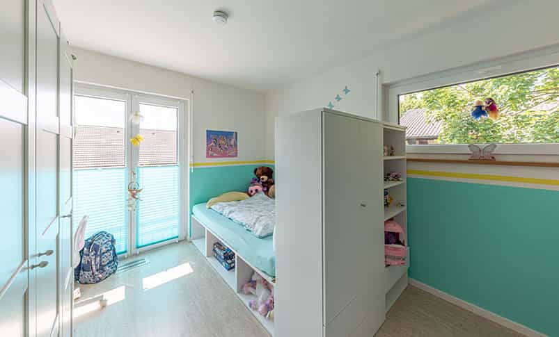 Kinderzimmer mit türkisfarbener Wand, Bett und Regal im Doppelhaus Haas D 114 B