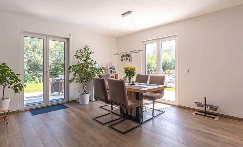 Esszimmer mit Holztisch, Pendelleuchte und Terrassentür im Doppelhaus Haas D 137 B