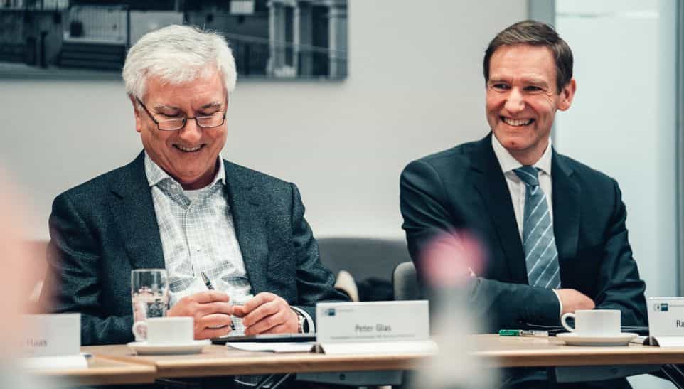 Zwei Teilnehmer der IHK-Gremiumssitzung Rottal-Inn im Gespräch am Konferenztisch bei Haas Fertigbau