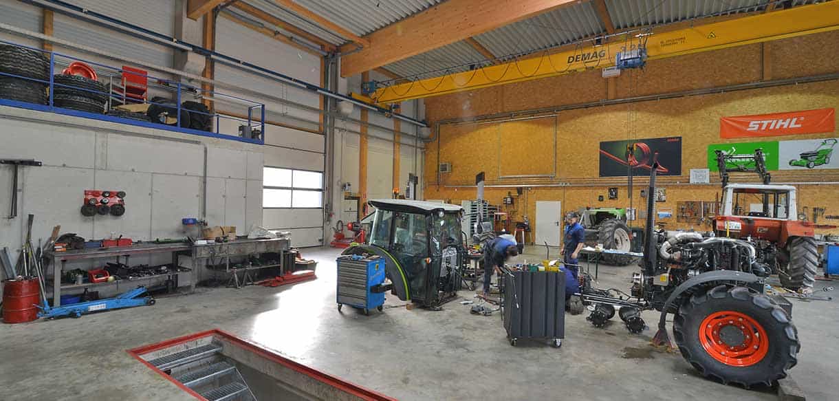 Werkstatt von Landtechnik Embacher mit Kranbahn, Traktoren und Montagegrube