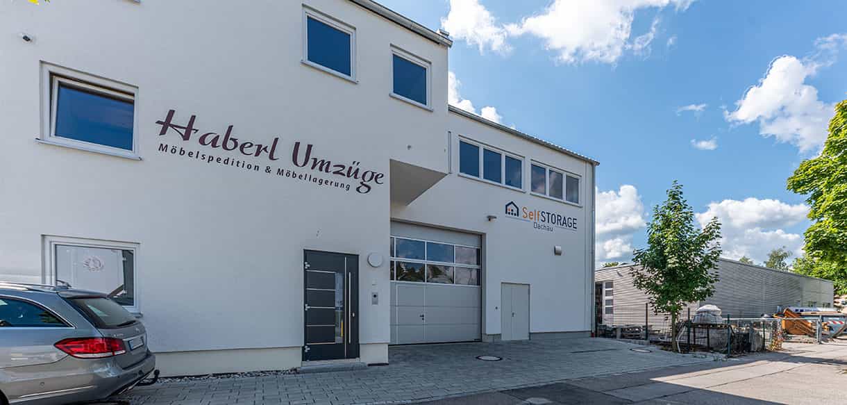 Fassade mit Firmenschriftzug Haberl Umzüge, Eingangstür und Hallentor am Anbau von Haas Gewerbebau