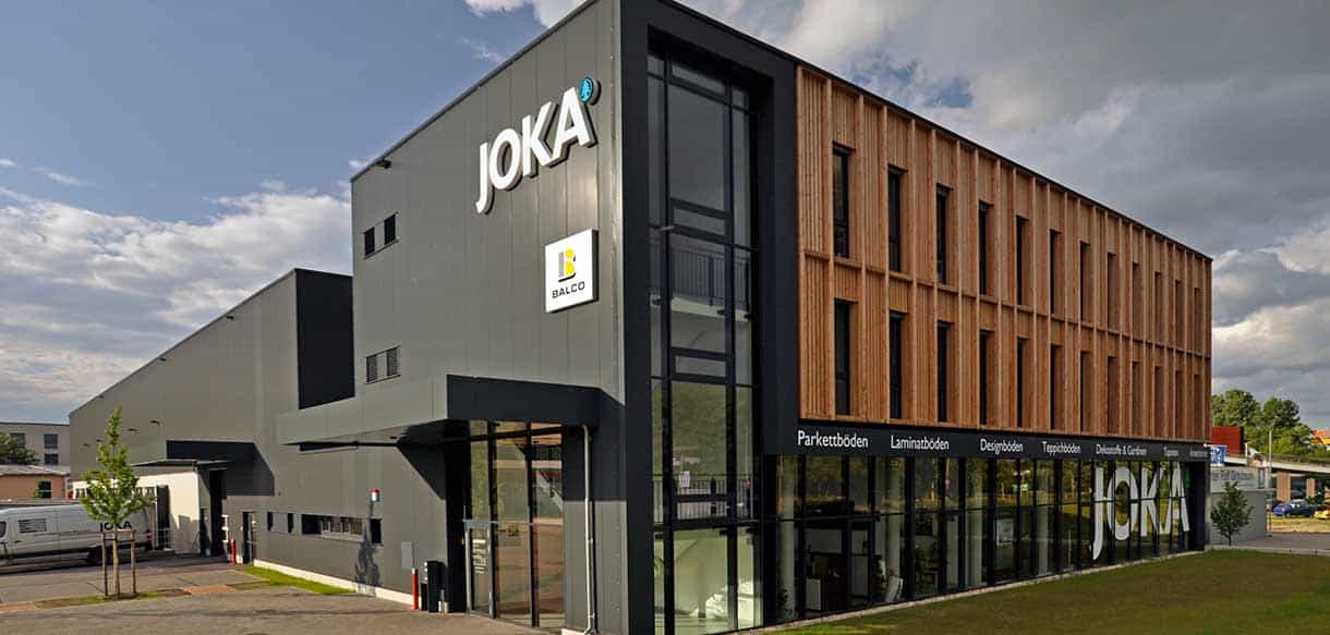Eckansicht des JOKA Bürogebäudes von Jordan mit Holzlamellenfassade und Logo