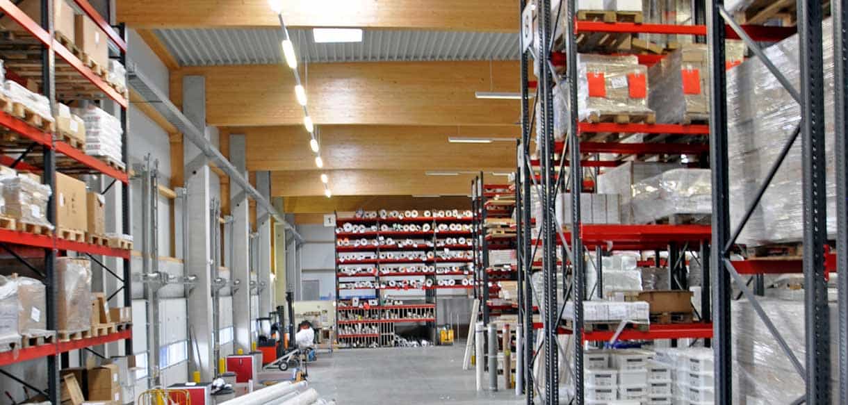 Lagerhalle der Firma Jordan mit Hochregalen und Holzdachkonstruktion
