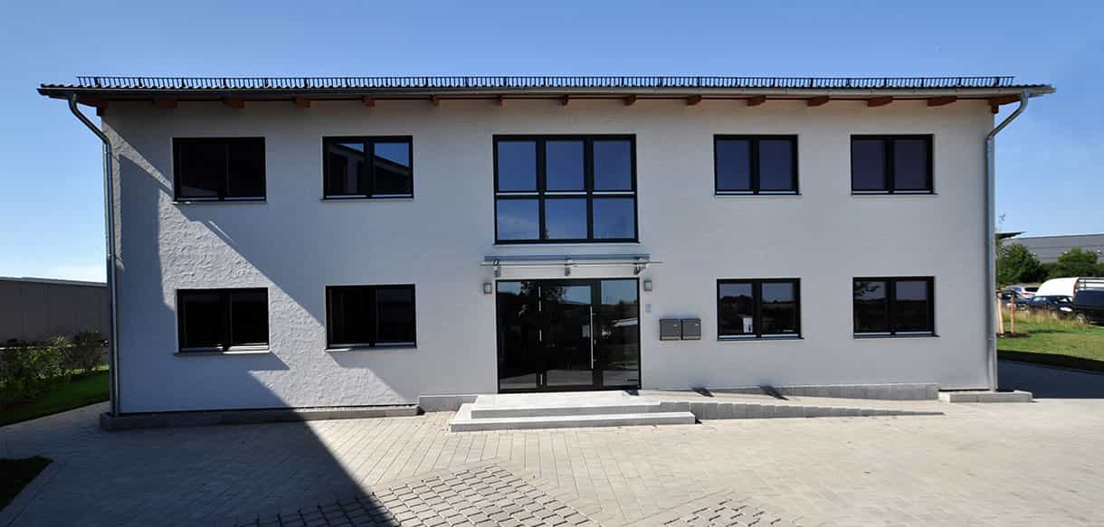Zweigeschossiges Bürogebäude der Waldbesitzervereinigung Pfaffenhofen mit Eingangsbereich und gepflastertem Vorplatz, Haas Gewerbebau