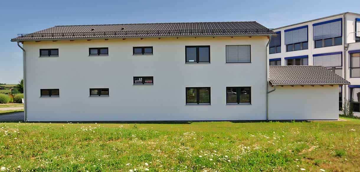 Seitliche Außenansicht des Bürogebäudes mit Lageranbau der Waldbesitzervereinigung Pfaffenhofen auf der Wiese
