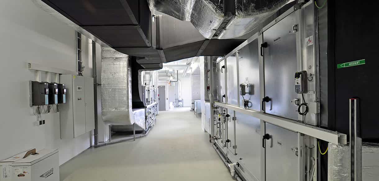 Lüftungszentrale mit Lüftungsgeräten und Luftkanälen in der Lagerhalle von Adler Lacke