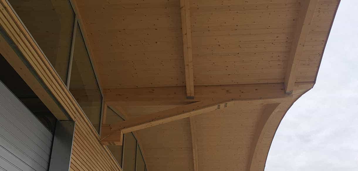 Detail des geschwungenen Leimholz-Vordachs an der Lagerhalle von G & H Scheibelhofer Reben