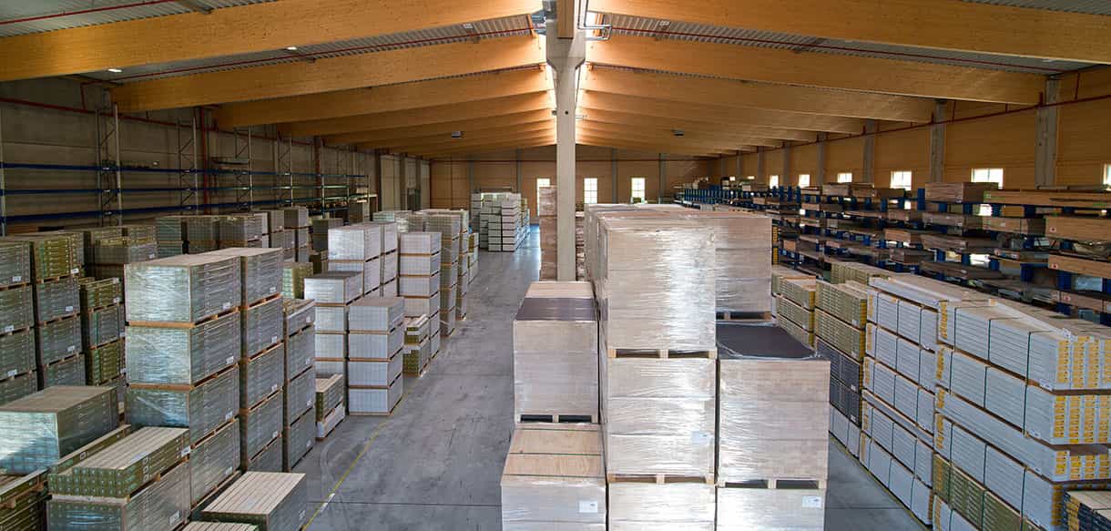 Lagerhalle Scheucher Holzindustrie von innen mit Holzpaketen, Regalreihen und hellem Holztragwerk