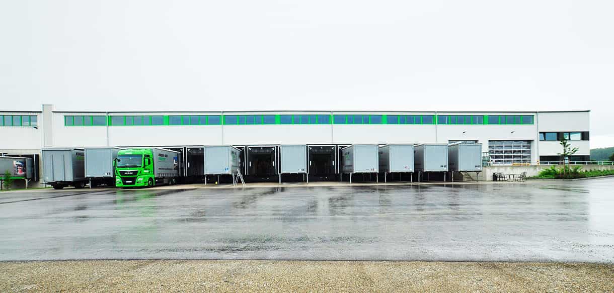 Laderampen der Versandhalle Süd-Fensterwerk mit angedockten Lkw-Aufliegern in der Frontansicht