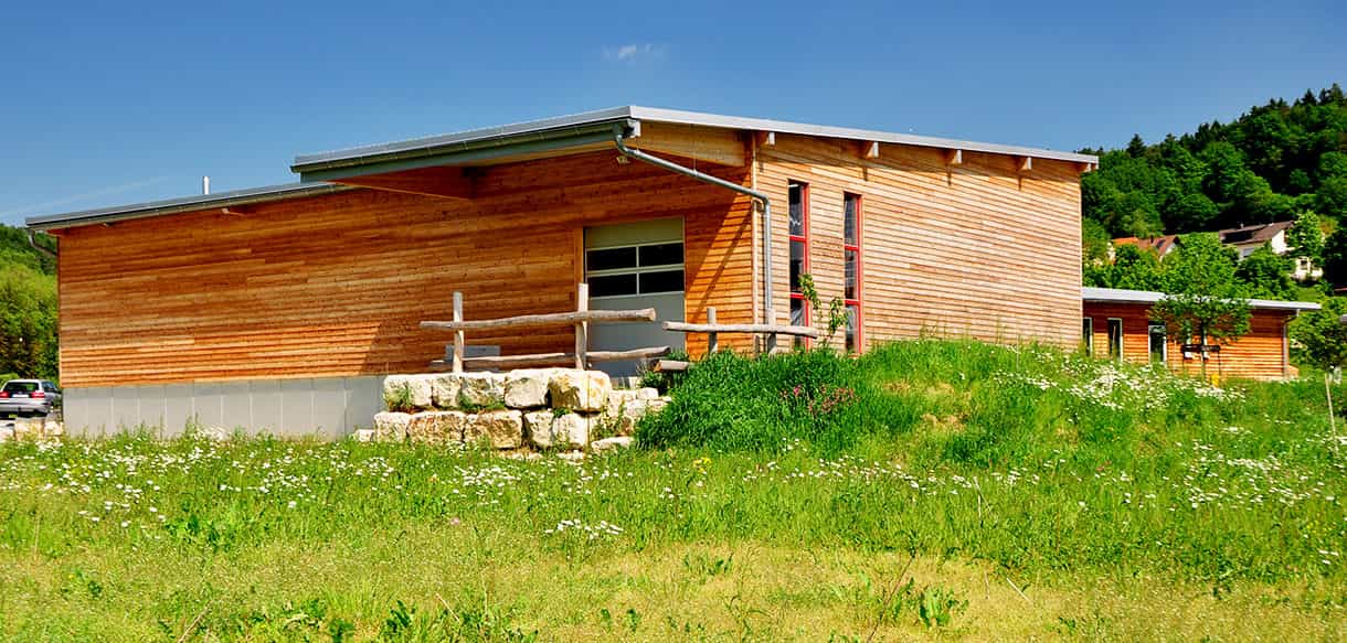 Lagerhalle mit Holzfassade und Flachdach der Beerenbauern Bertelshofer und Batz auf der Wiese
