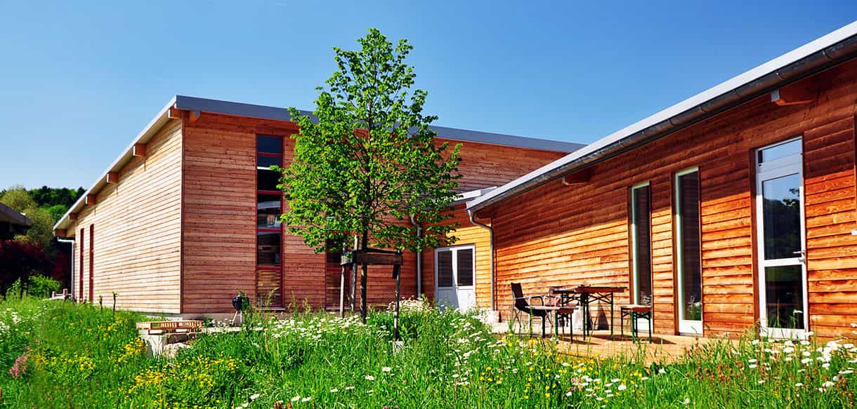 Holzfassade mit Terrasse und Eingang am Zwischenbau der Lagerhalle der Beerenbauern Bertelshofer und Batz