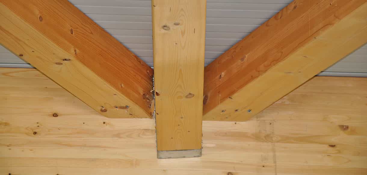 Detail der Holzkonstruktion mit Stütze und Trägern in der Lagerhalle der Beerenbauern