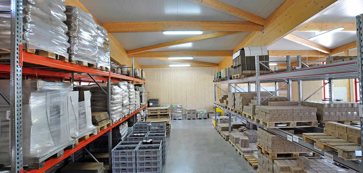 Palettenregale mit Obstkisten unter der Holzdachkonstruktion in der Lagerhalle der Beerenbauern