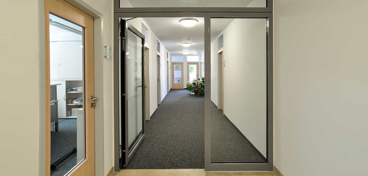 Flur mit Glastüren und Teppichboden im Bürogebäude Kaiser