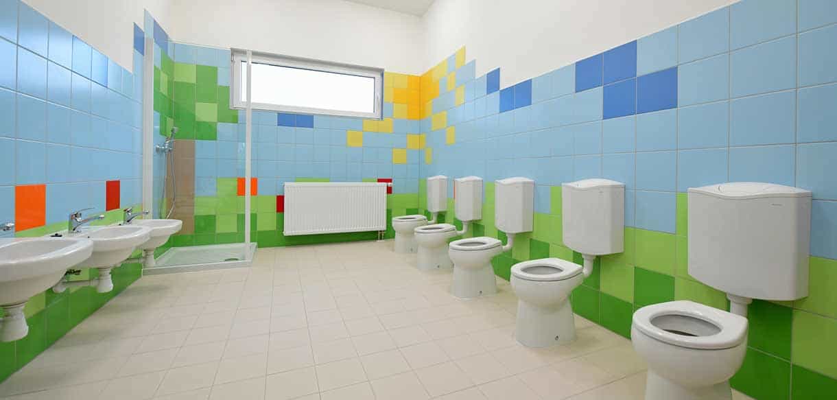 Kindersanitärraum im Kindergarten Roztoky mit kleinen WCs und bunten Fliesen