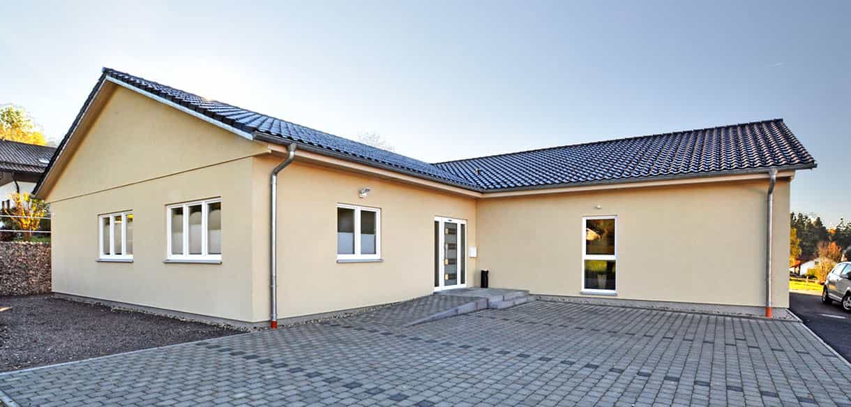 Physiotherapiepraxis Zielke von Haas Gewerbebau als Winkelbau mit beiger Fassade und gepflastertem Hof