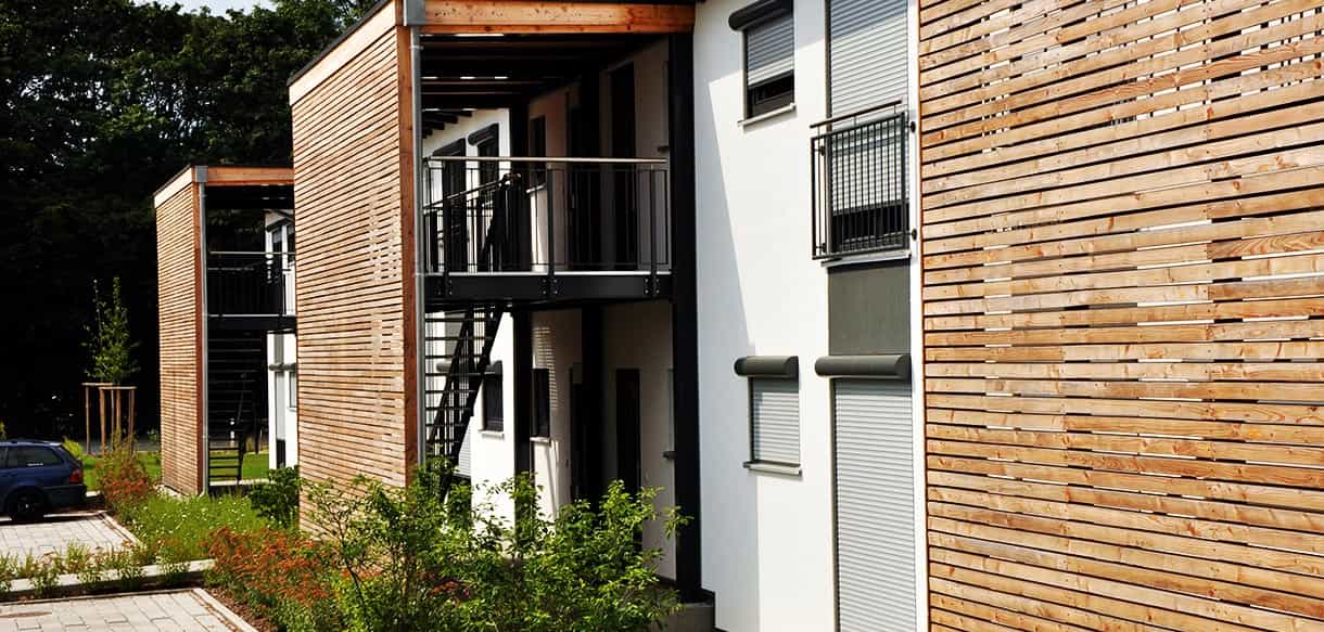 Detail der waagrechten Lärchenverkleidung am Treppenhaus des Arbeiterwohnheims Ammer mit Balkon