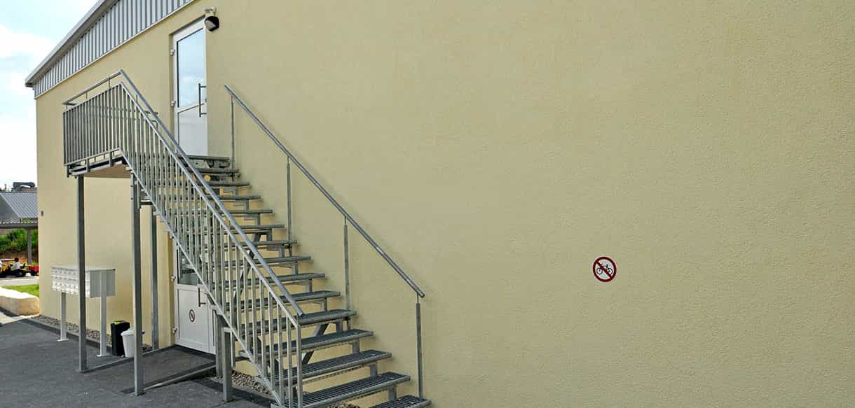 Stahlaußentreppe an der gelben Fassade des Asylbewerberheims in Neunkirchen am Sand