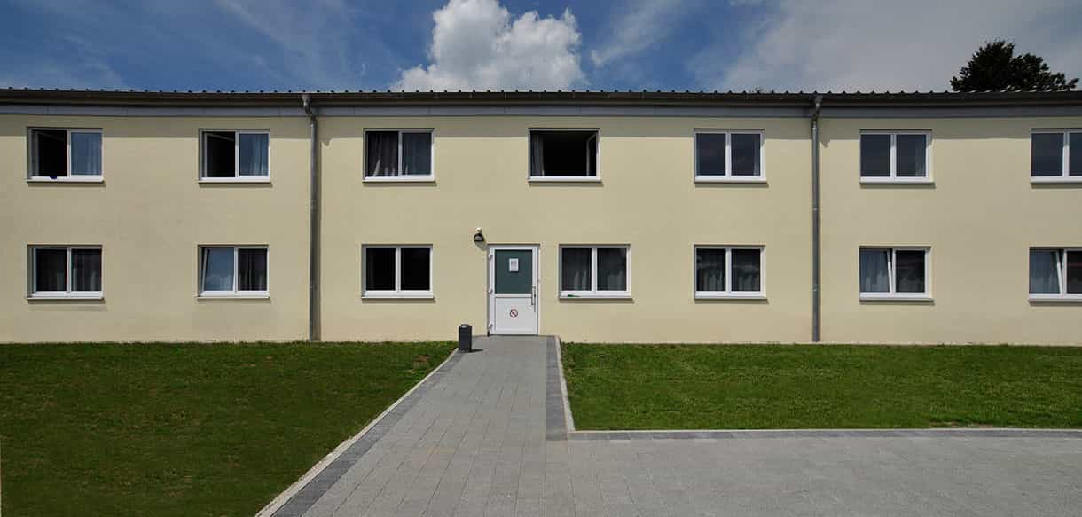 Frontansicht des Asylbewerberheims Neunkirchen am Sand mit Eingang und Rasenfläche