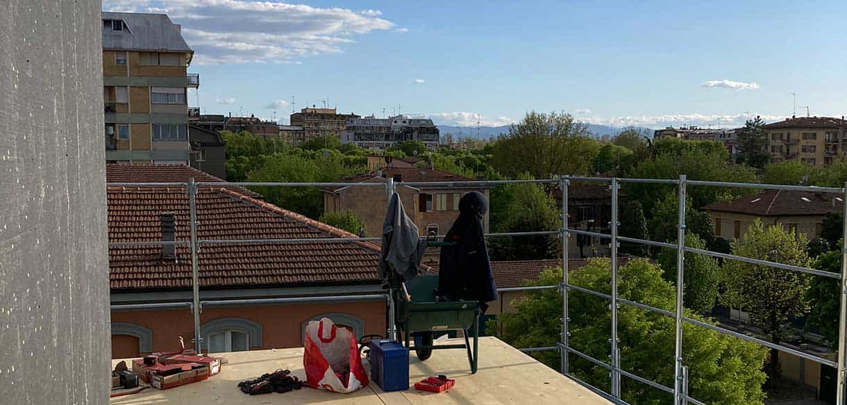 Baustelle des Hausbausatzes Alca in Modena mit Gerüst und Blick über die Dächer der Stadt