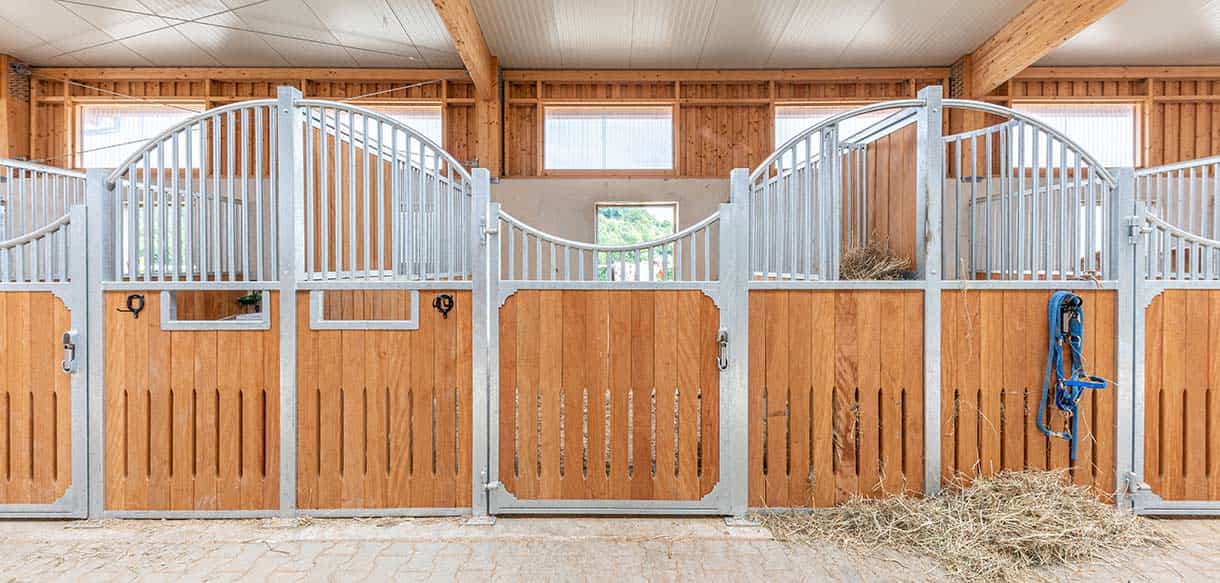 Pferdeboxen aus Holz und Metallgittern in der Reitanlage in Berglern