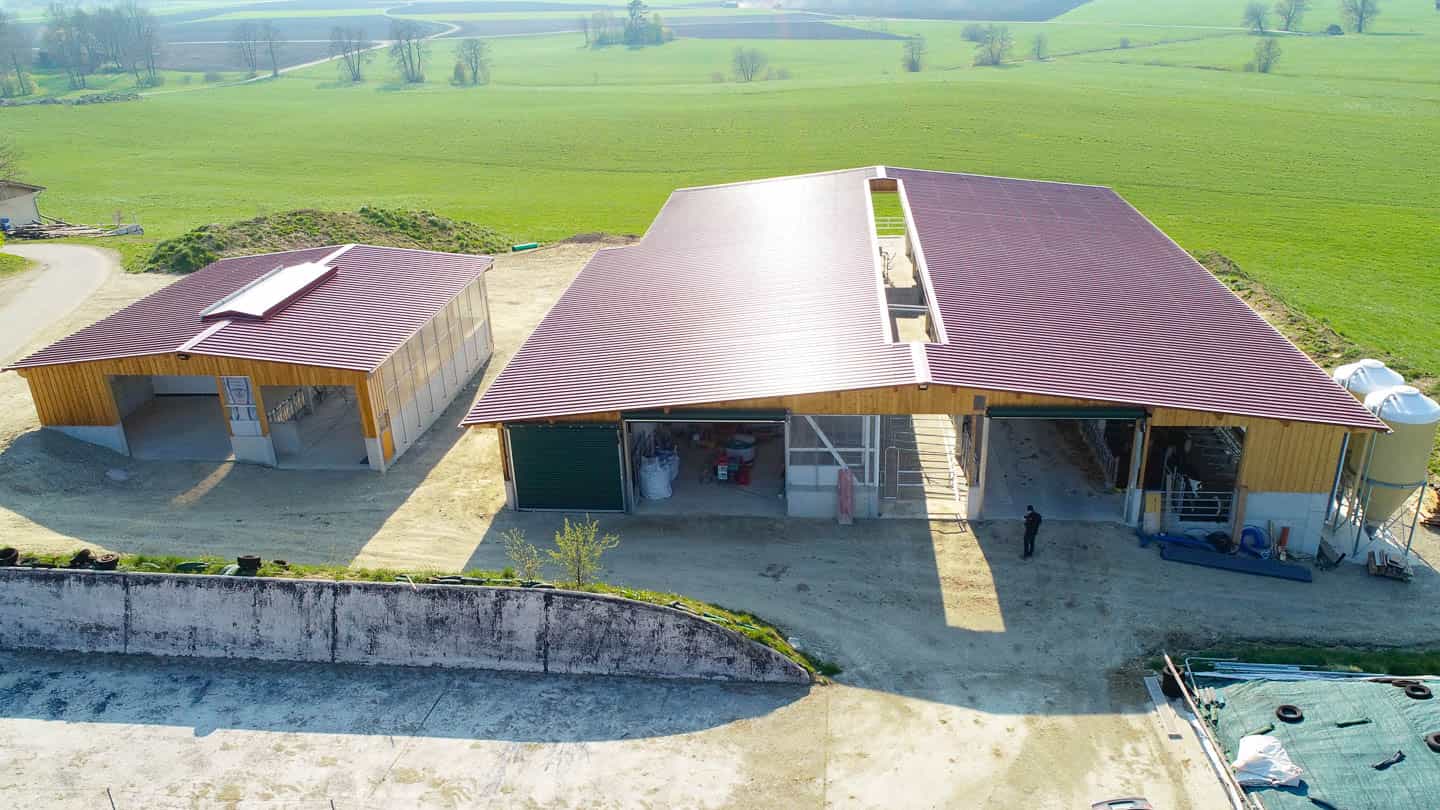 Luftaufnahme des Jungviehstalls in Rechtmehring mit rotem Dach, Fahrsilo und Feldern