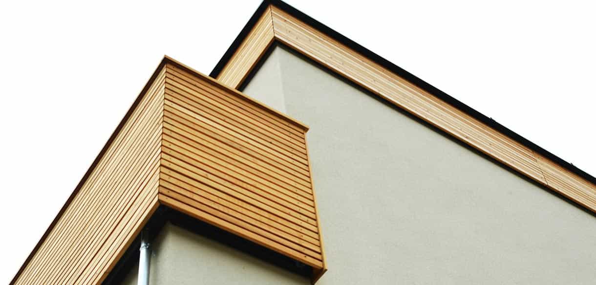 Detail eines holzverkleideten Balkons von unten an der Wohnhausanlage Mistelbach von Haas Fertigbau