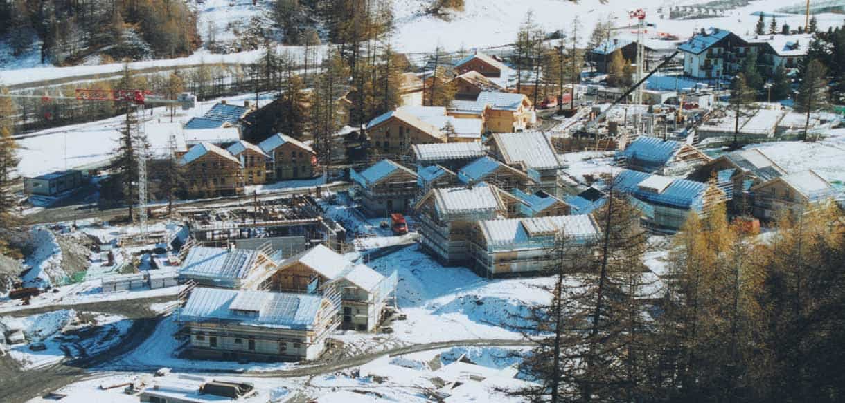 Luftaufnahme der verschneiten Ferienwohnanlage im Chalet-Stil in Pragelato von Haas Fertigbau