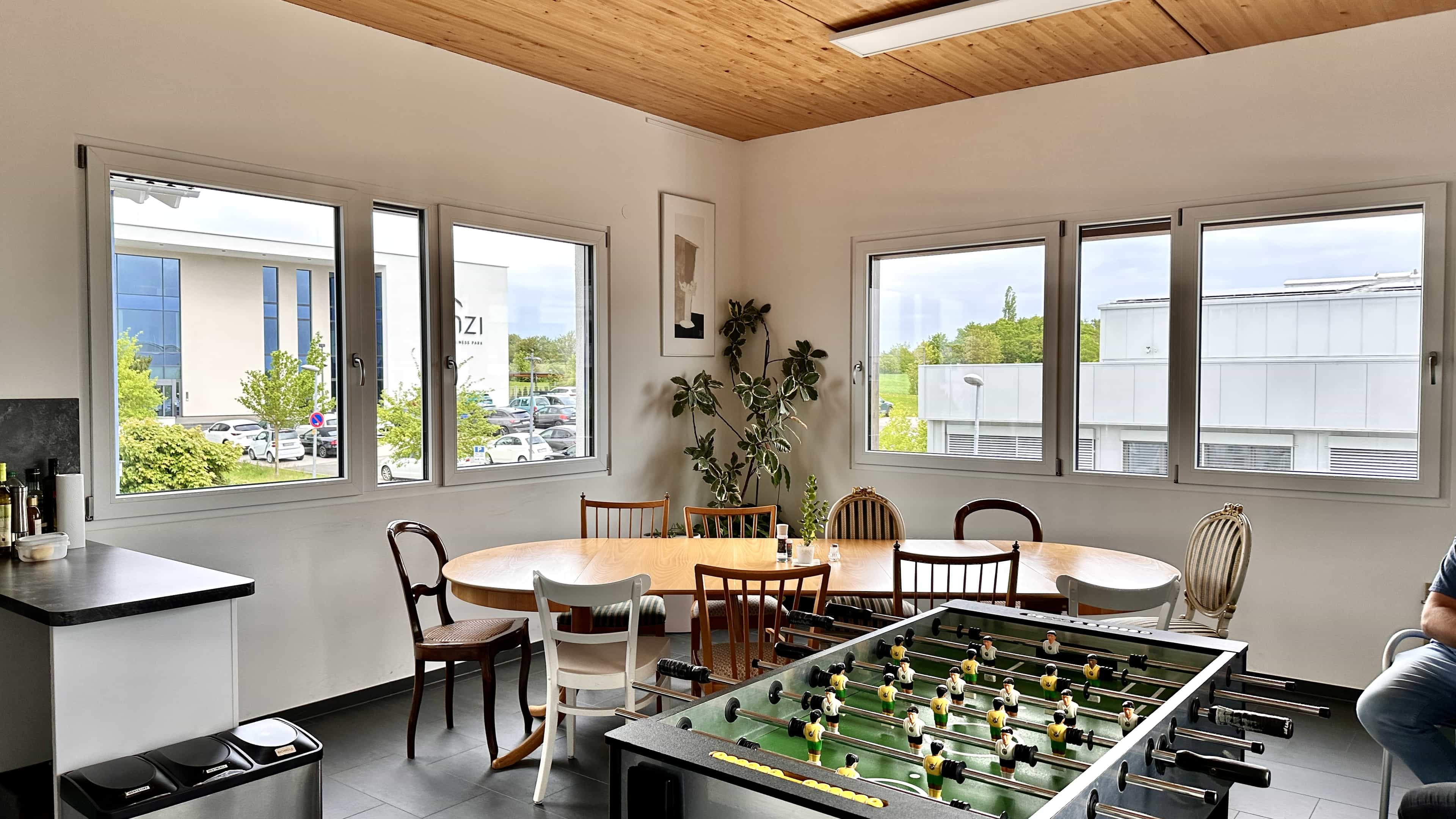 Pausenraum mit Kickertisch, rundem Tisch und Holzdecke bei LXinstruments