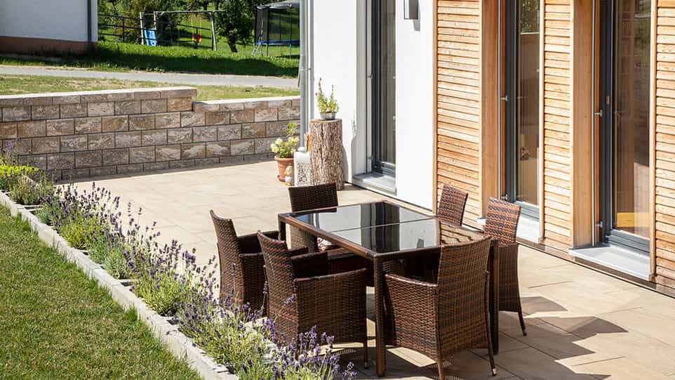 Terrasse mit Essplatz und Lavendelbeet an der Holzfassade des Haas Fertighauses der Familie Kroiß
