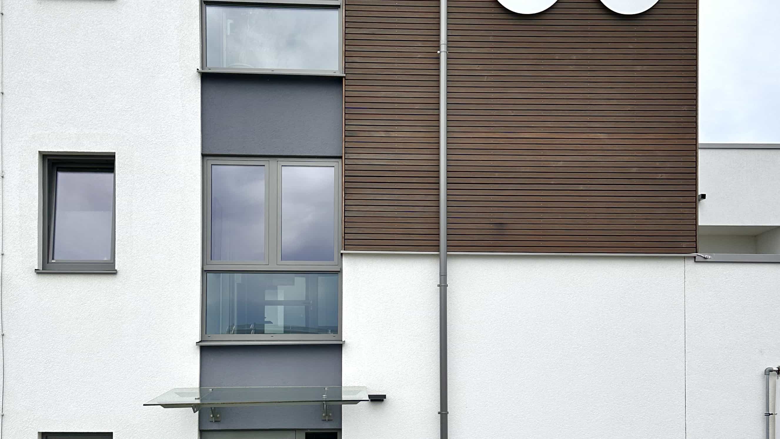Fassadendetail des Bürogebäudes LXinstruments mit Holzverkleidung und Fenstern