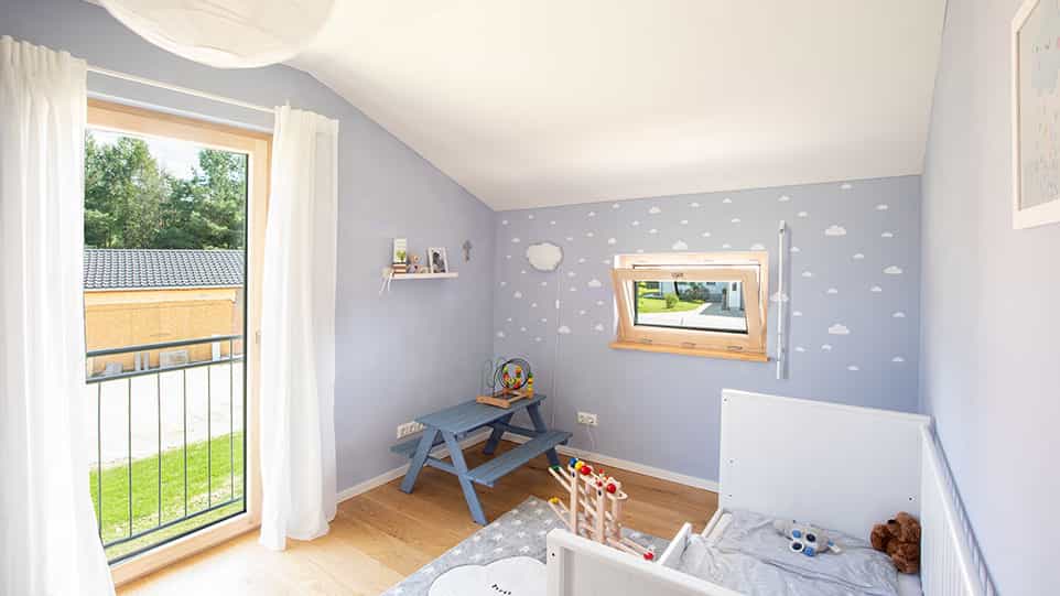 Kinderzimmer mit Wolkentapete und Balkontür im Haas Fertighaus der Familie Kroiß
