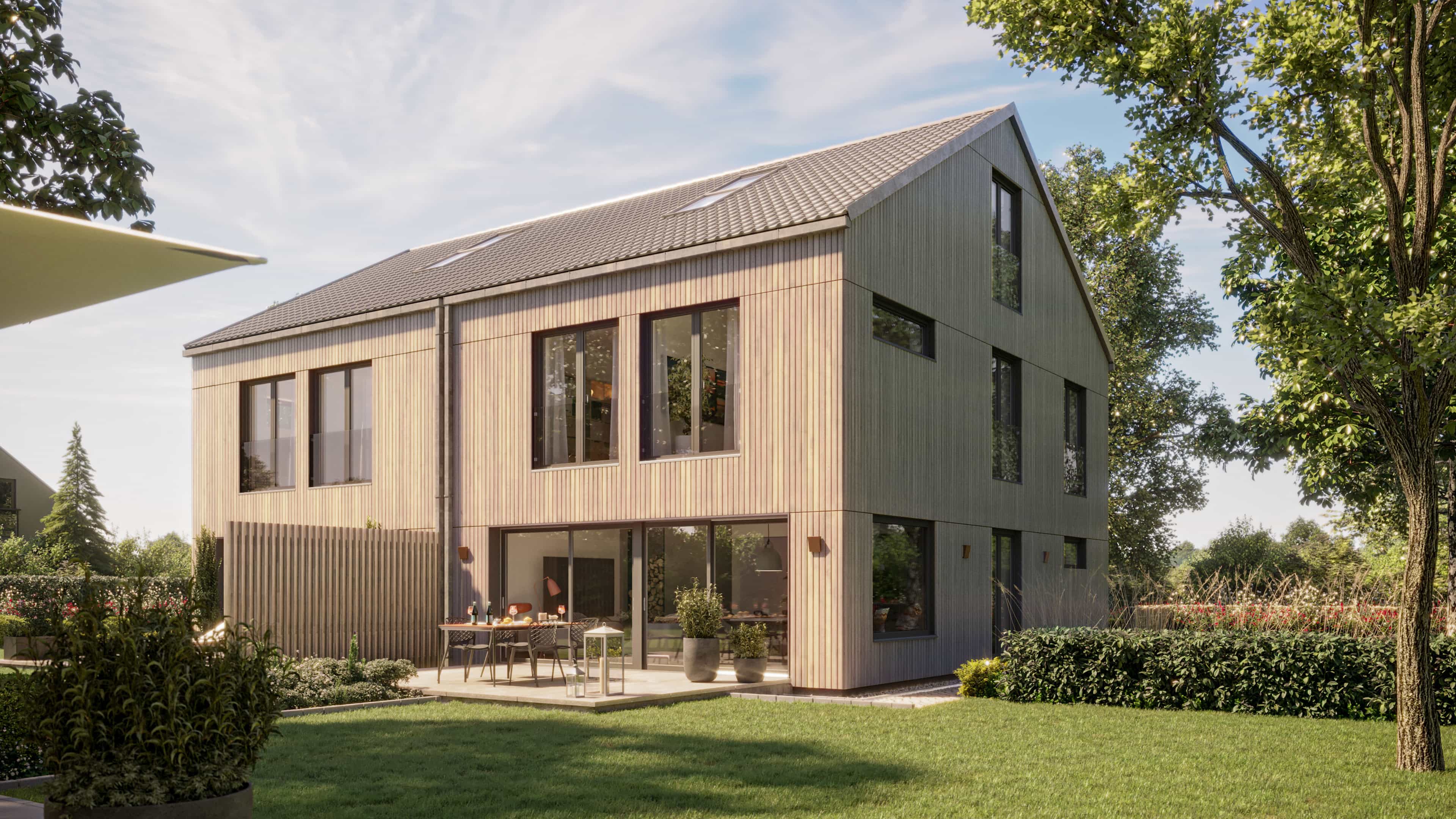 Modernes zweistöckiges Holzhaus mit großer Glasfront und möblierter Terrasse, umgeben von Rasen und Bäumen.