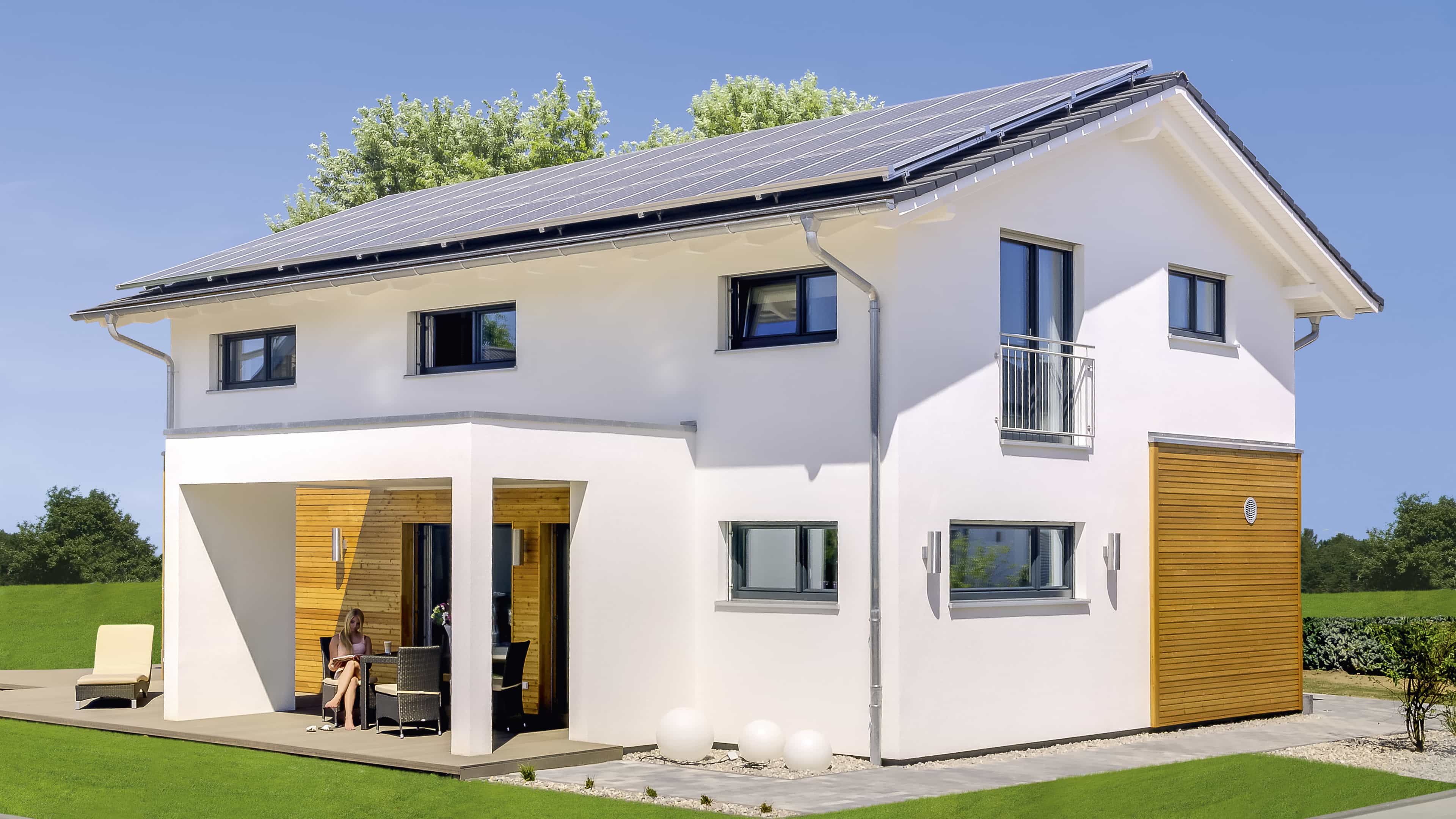 Terrassenseite des Musterhauses Haas MH Mannheim J 159 mit Photovoltaikdach bei Tag