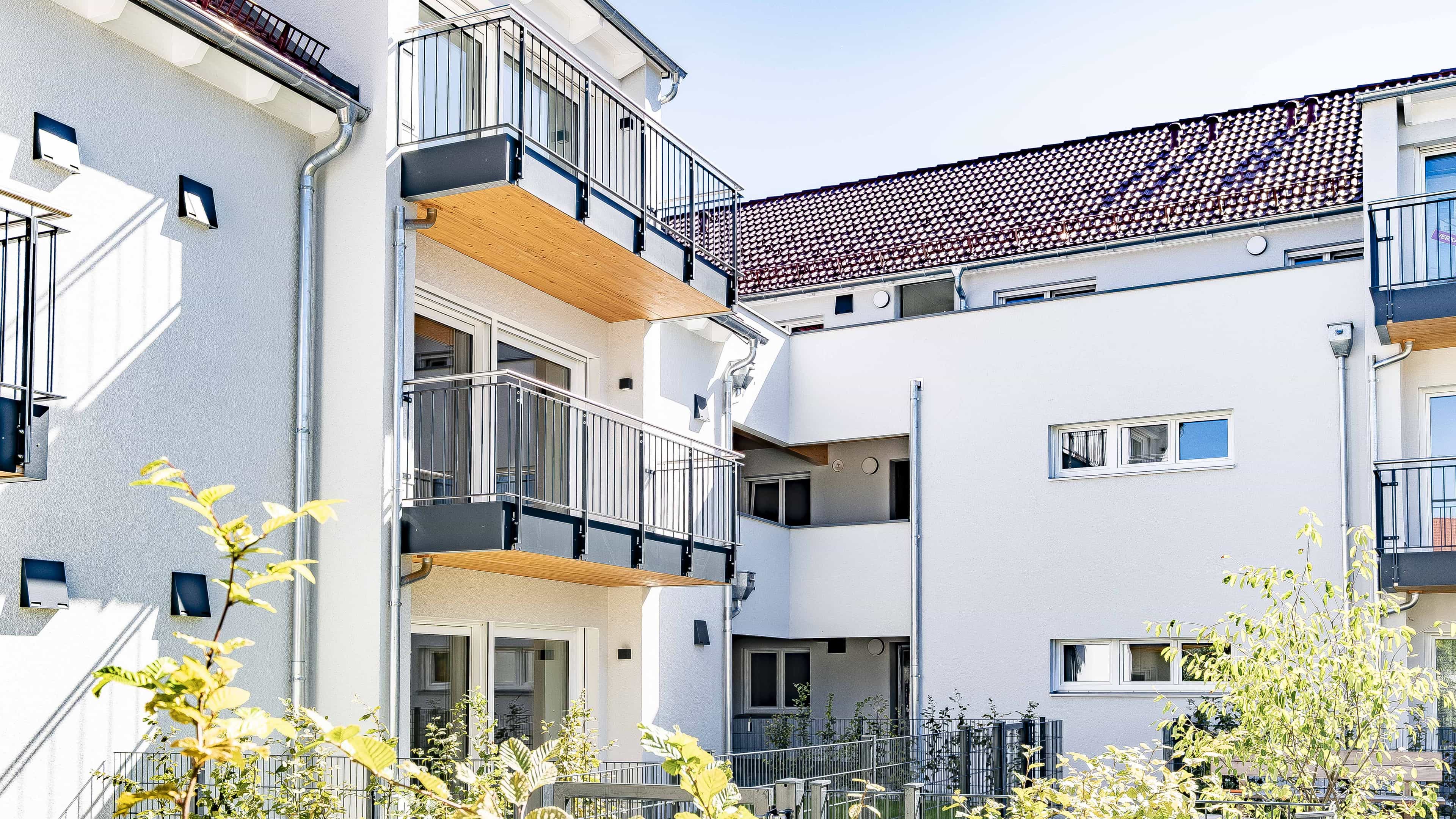 Innenhof des Wohnbauprojekts Eching mit Balkonen und Holzelementen an den Fassaden