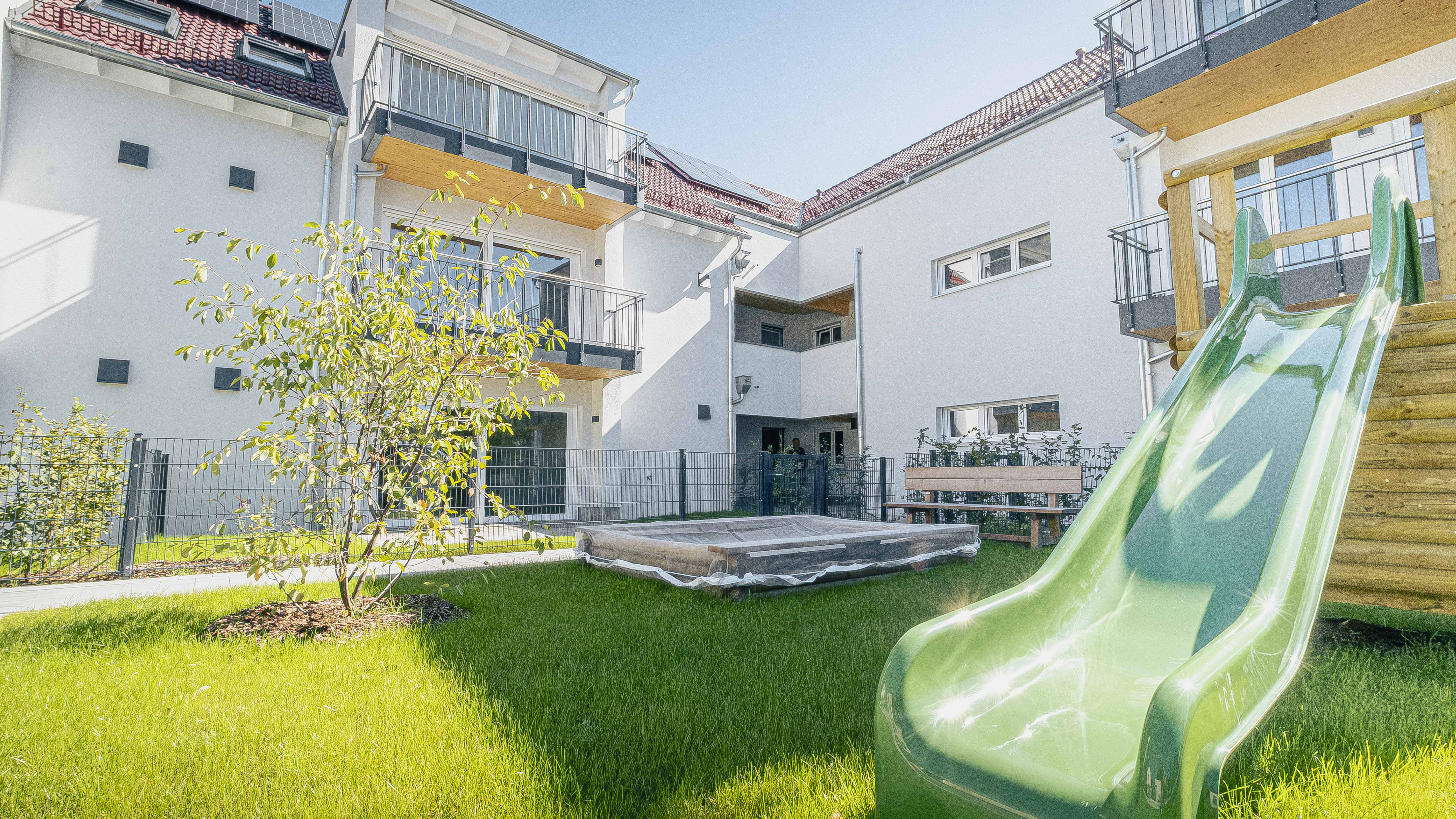 Garten mit Rutsche und Spielbereich vor der Wohnanlage mit 15 Wohneinheiten in Eching