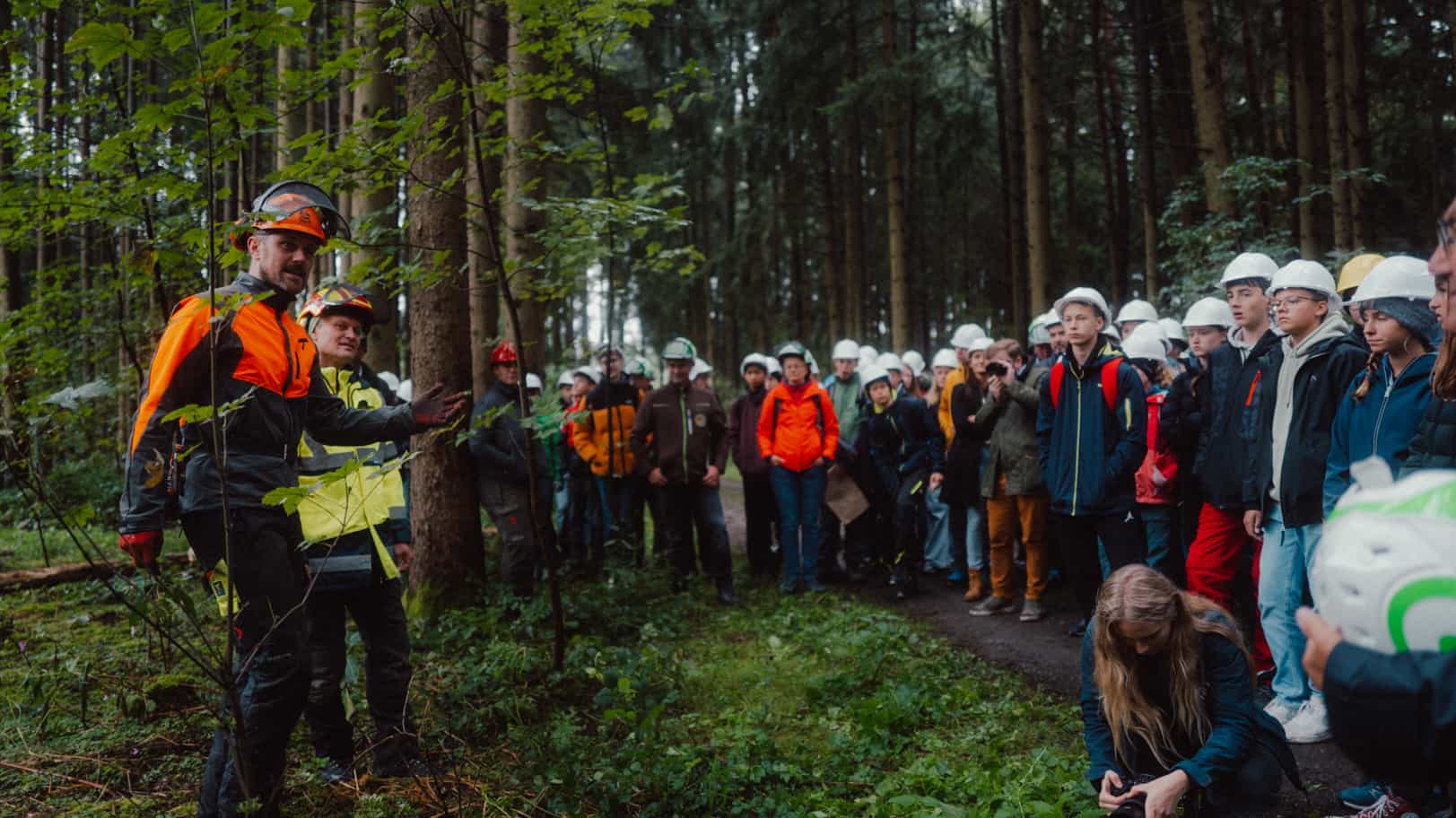 Teilnehmergruppe mit Schutzhelmen bei einer Waldbegehung, Auftakt der Initiative Holz Rettet Klima in Falkenberg