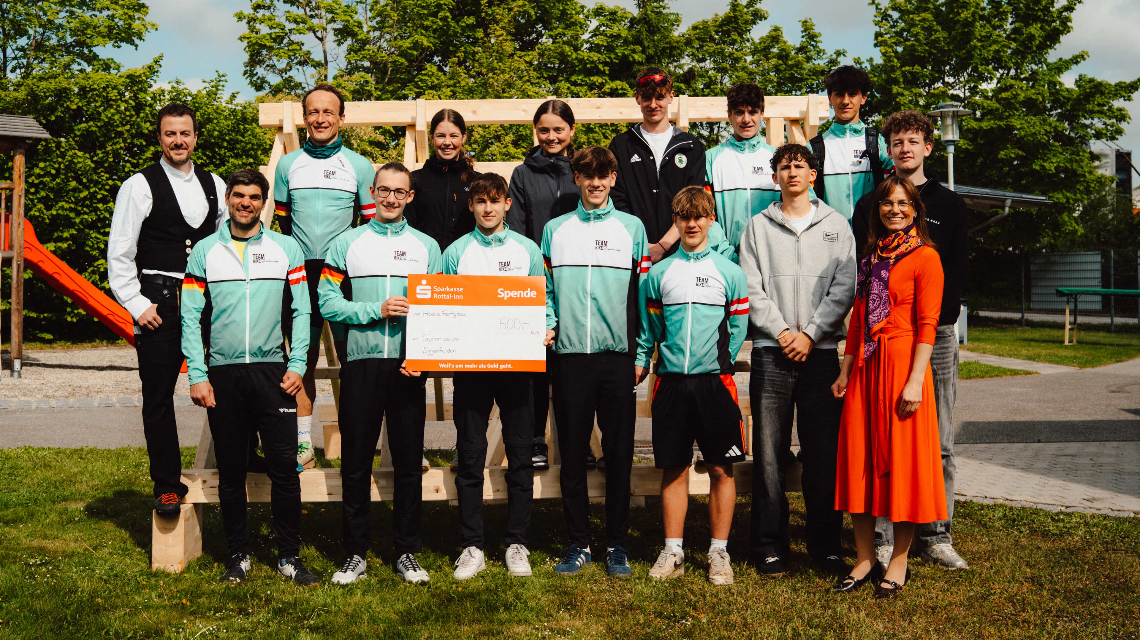 Gruppenfoto mit Radsportteam in Trikots auf der Wiese beim Berufsinfotag von Haas Fertigbau in Falkenberg