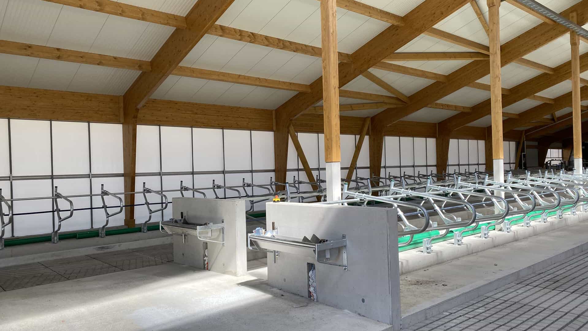 Neue Liegeboxen mit Holzbinderdach und offener Seitenwand im Milchviehstall in Marzling