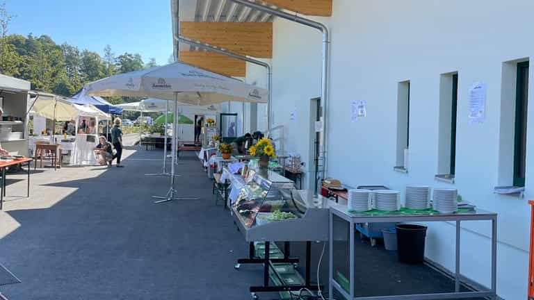 Festbereich mit Sonnenschirmen und Buffettischen vor dem Betriebsgebäude, Einweihungsfeier der Ökokiste Donau-Wald