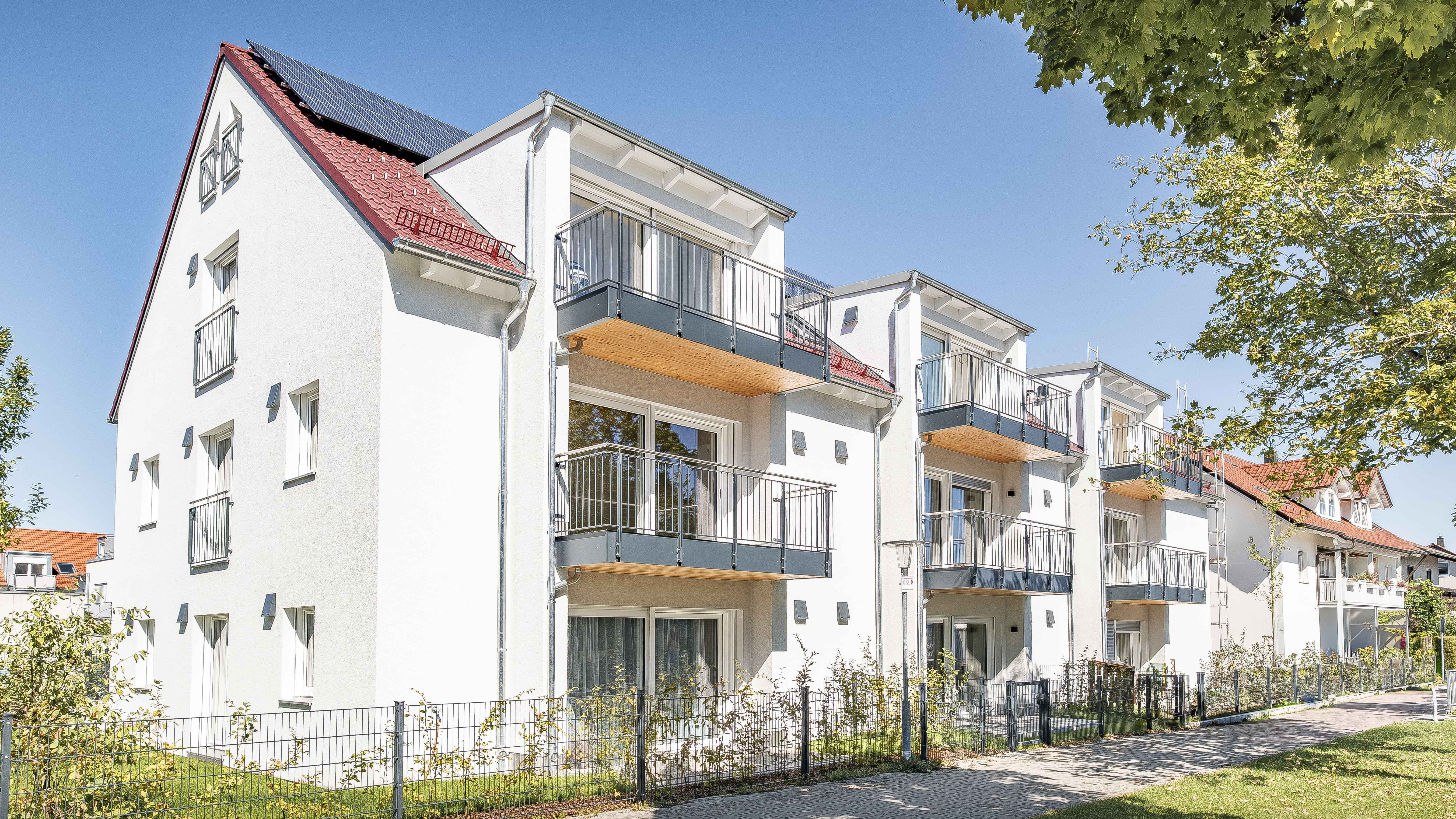 Straßenansicht der dreigeschossigen Wohnanlage mit 15 Wohneinheiten und Balkonen in Eching von Haas Wohnbau