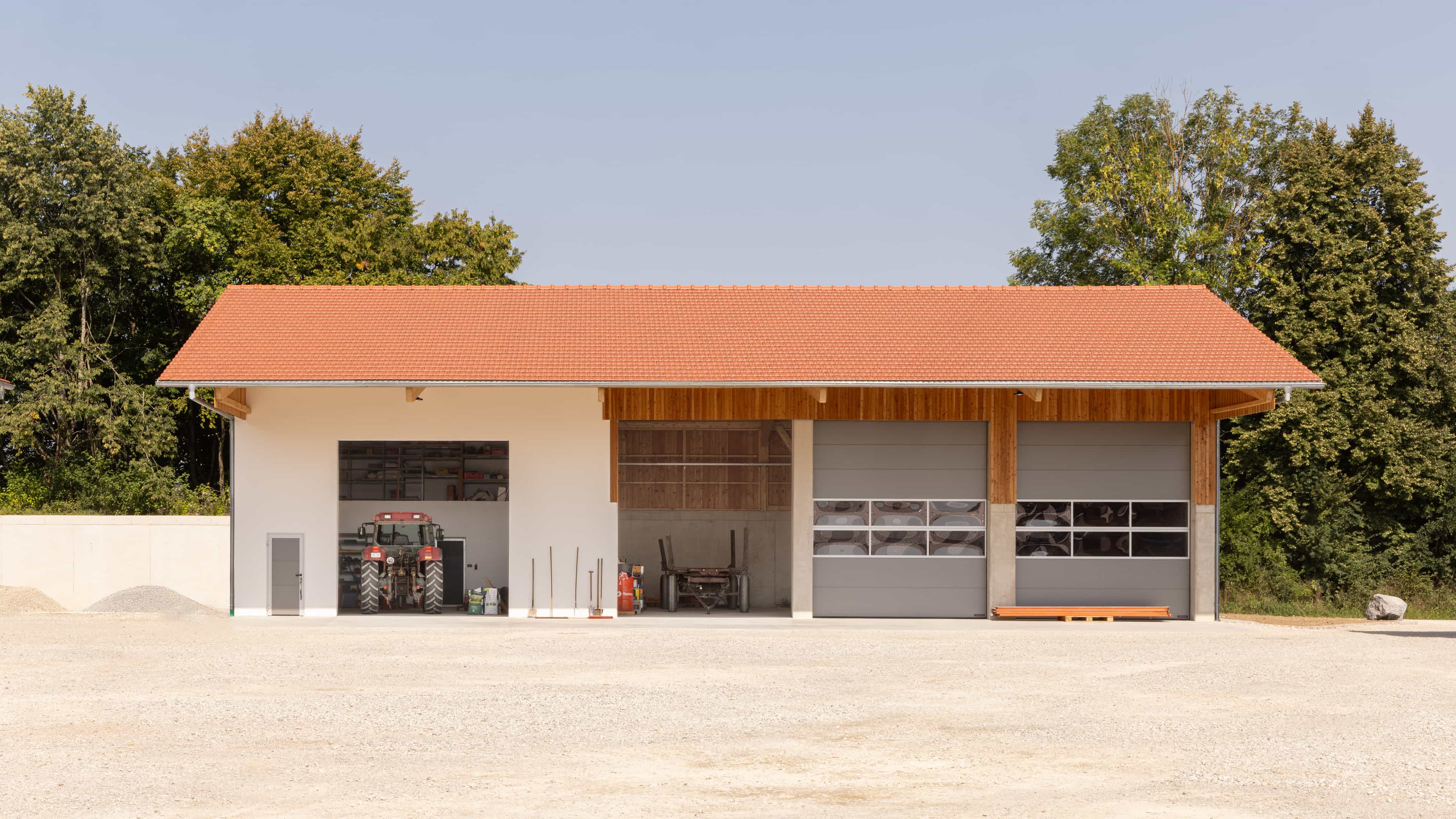 Halle in Wang mit Ziegeldach, Holzfassade, Toren und Traktor davor