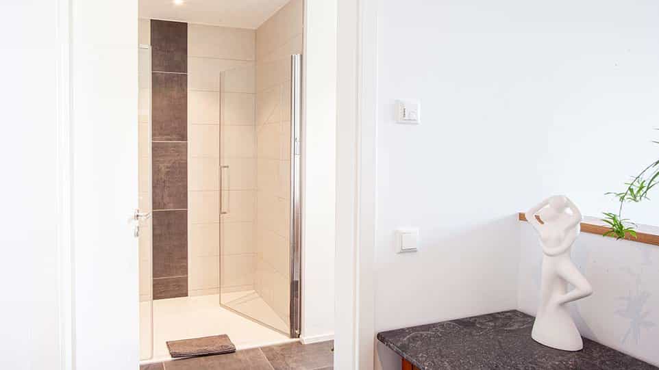 Ebenerdige Dusche mit dunklem Fliesenstreifen im Bad der Familie Kurzenknabe